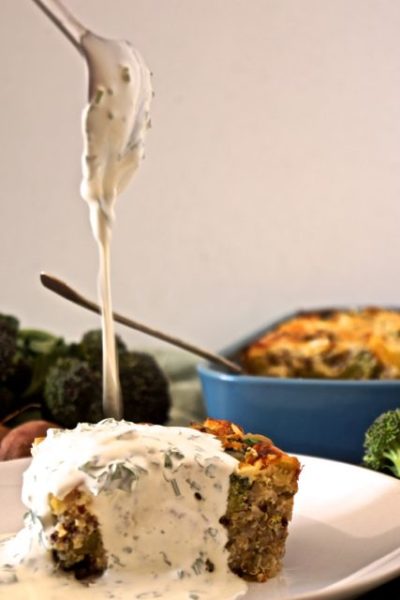 Sourcream sauce dripping onto a piece of the bake