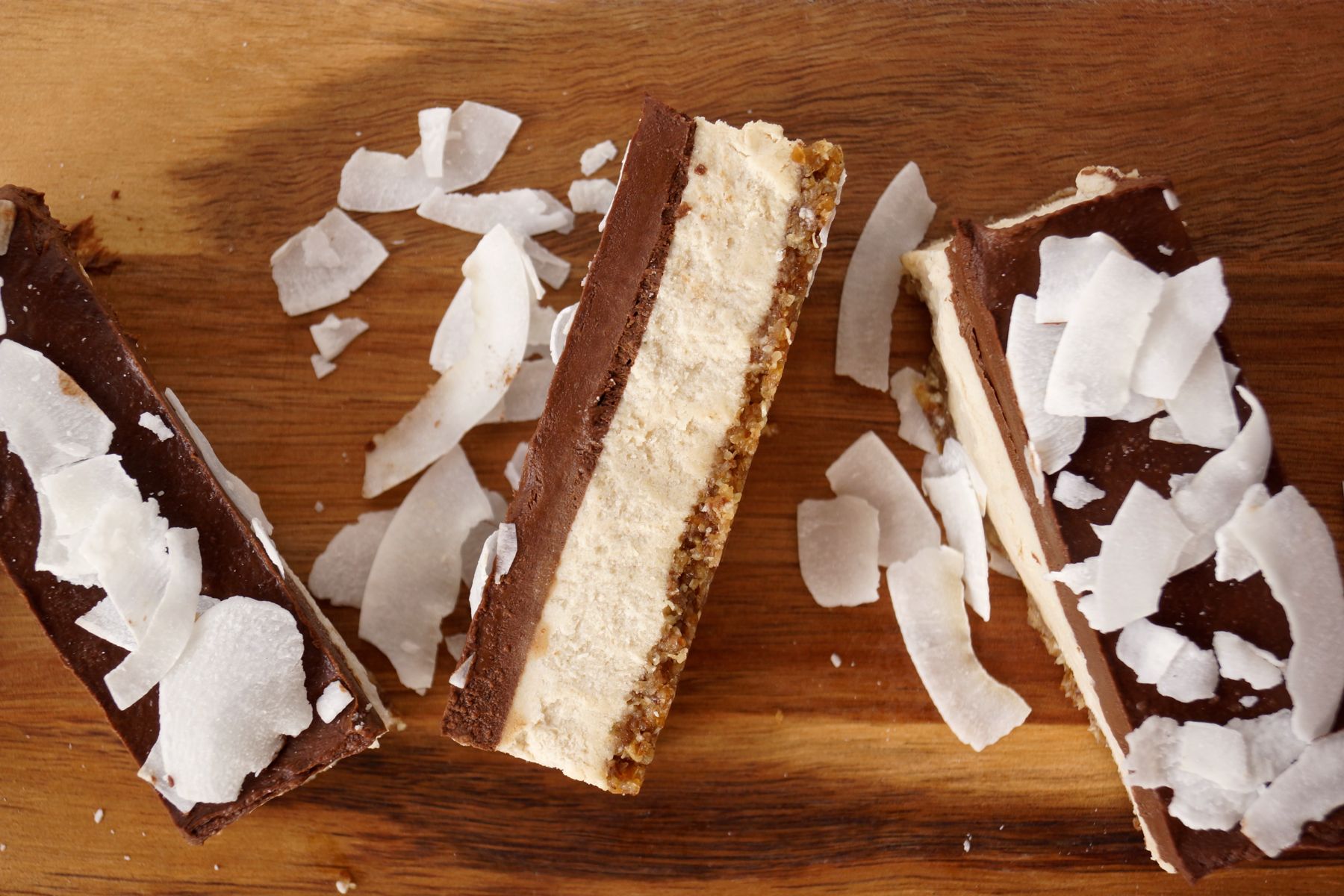 Decadent Chocolate-Coconut Cheesecake Bars on a wooden tray
