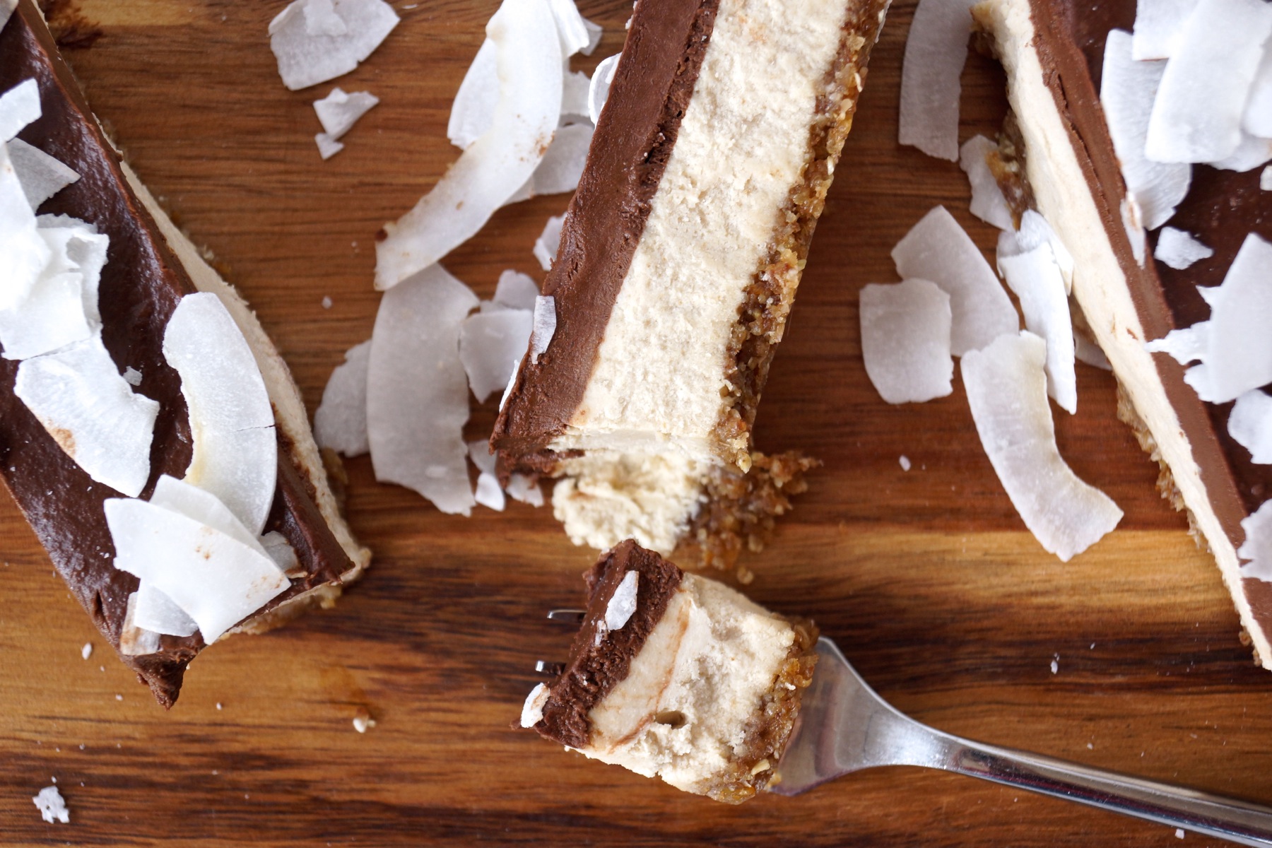 A bite of the 3-layered Chocolate-Coconut-Cheesecake-Bars