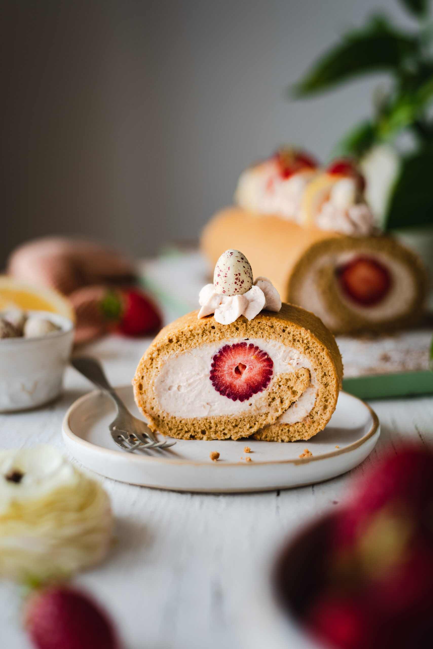 A slice of strawberry white chocolate biscuit roll