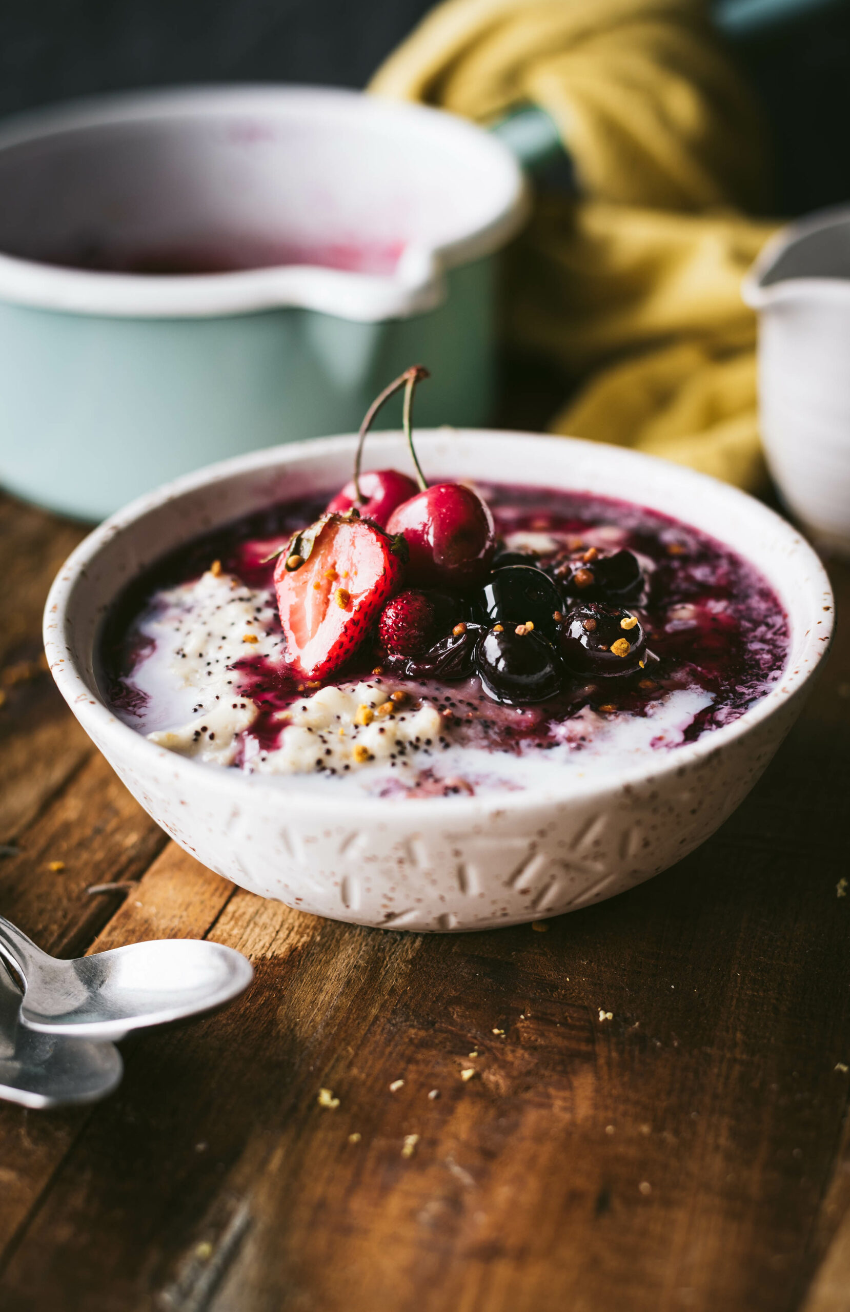 A bowl of creamy Amaranth Oat Porridge topped with freshly stewed summer berries