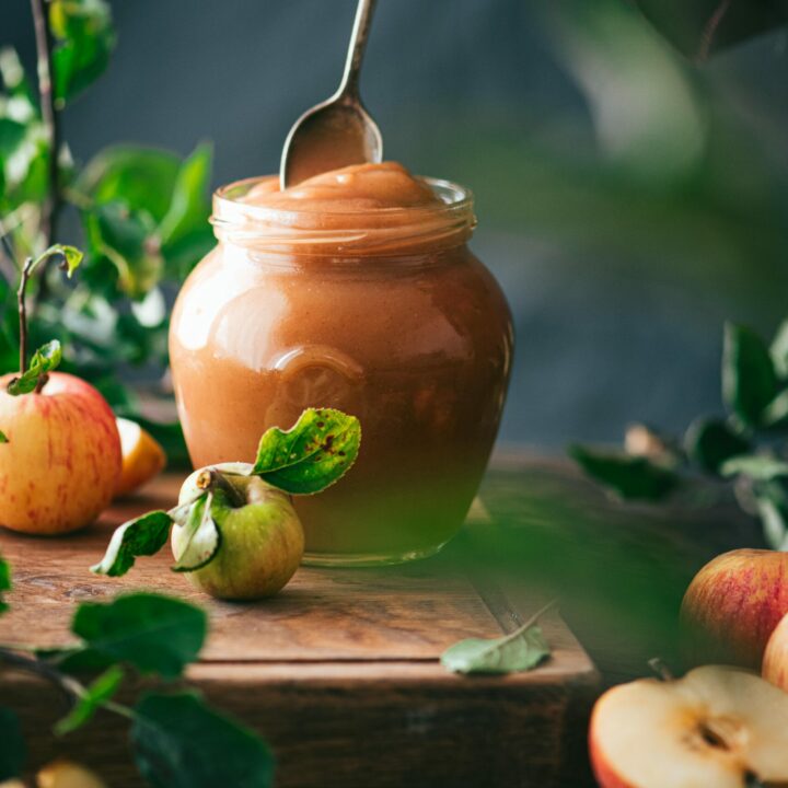 A maison jar filled to the brim with oven-baked apple butter.